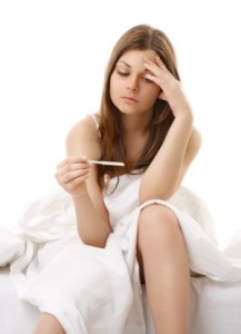 The afflicted girl sits in bed and sees result of the test for pregnancy